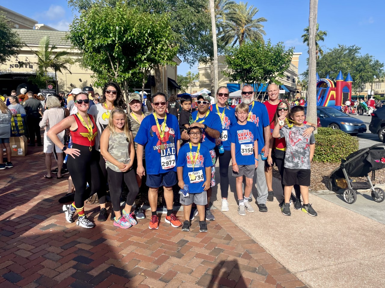 14 people smiling at charity event with medals they received